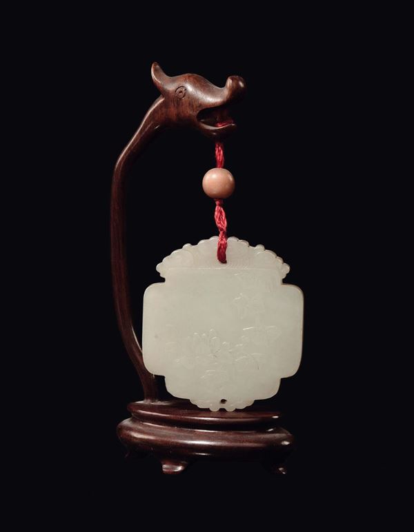 A white jade pendant with wooden dragon base, China, Qing Dynasty, 19th century