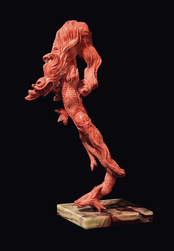 A sculpted “dragon with wise man faces” coral, wooden base, China, early 20th century