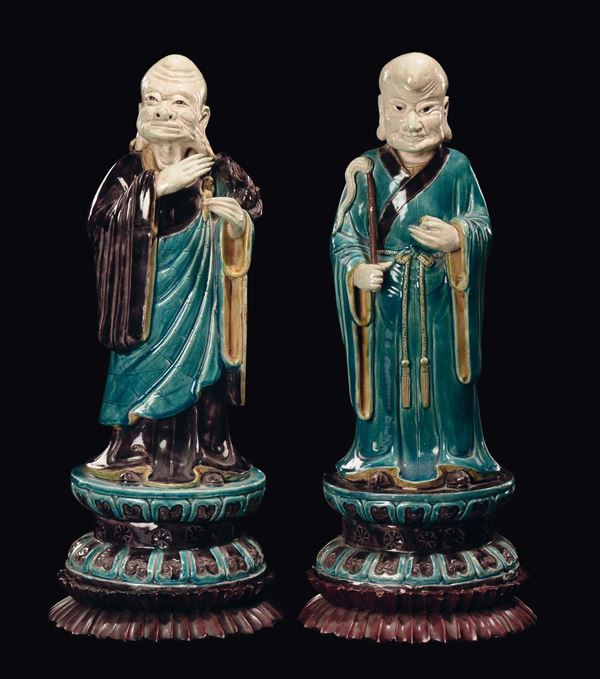 A pair of porcelain dignitaries with turquoise and aubergine enamels, China, Qing Dynasty, Kangxi Period (1662-1722)