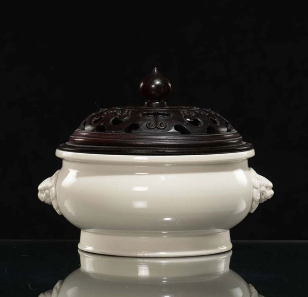 A Blanc de Chine porcelain censer, Dehua, and fretworked wooden cover, China, Qing Dynasty, late 17th  [..]