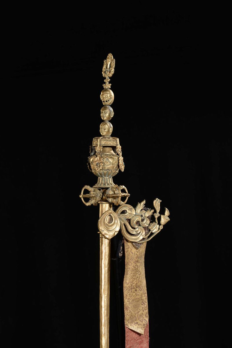 Bastone Rituale in Bronzo Dorato con Decoro Sormontato da Immagini di Teste e Teschio, Tibet, XVI...