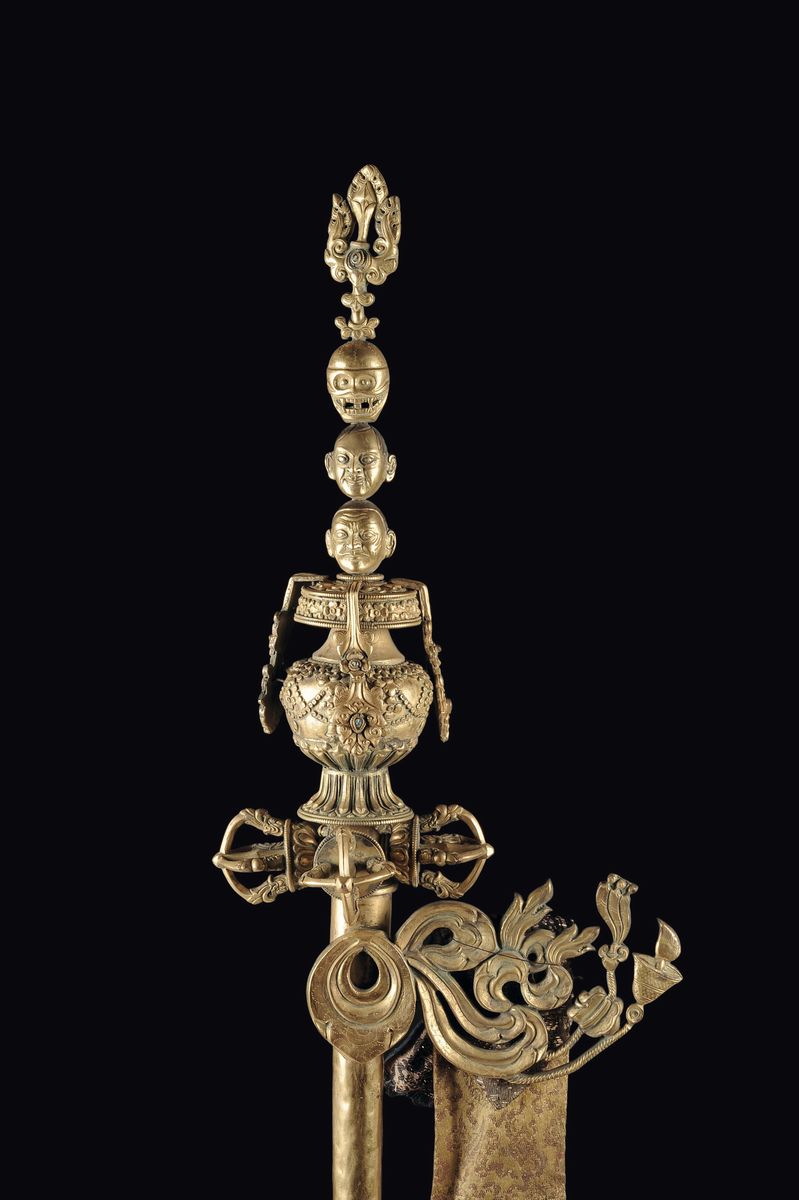 Bastone Rituale in Bronzo Dorato con Decoro Sormontato da Immagini di Teste e Teschio, Tibet, XVI...