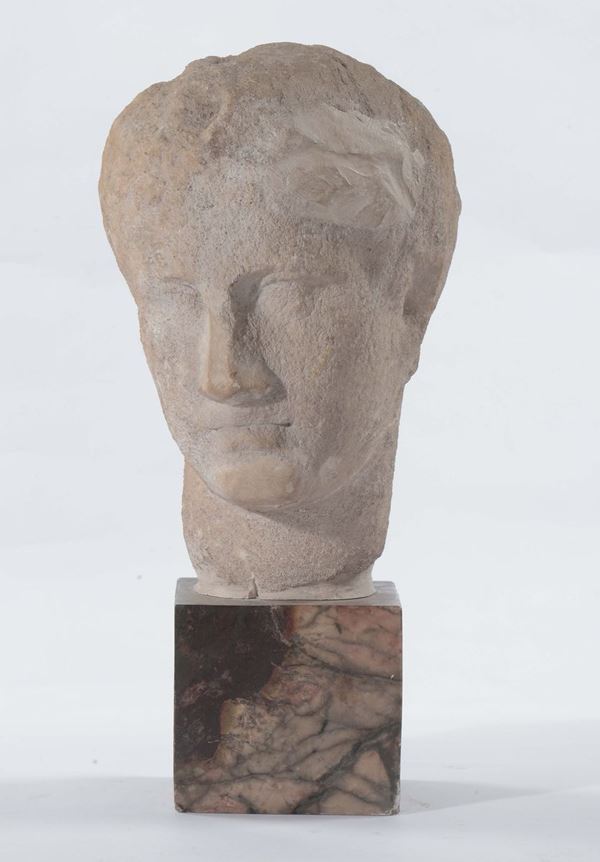 Testa in pietra scolpita