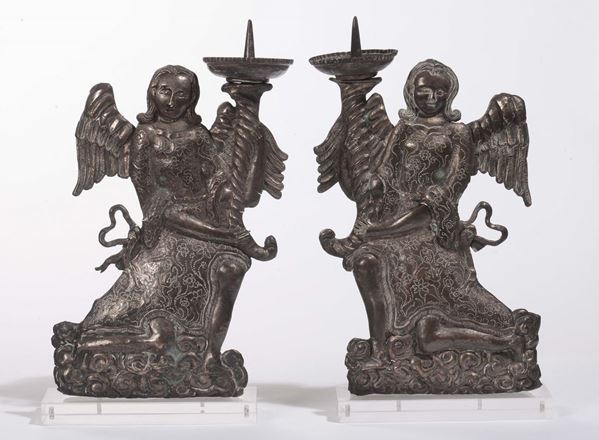Due angeli genuflessi in rame sbalzato e argentato