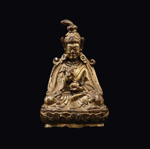 Piccola figura di Lama in bronzo dorato seduta su fiore di loto, Tibet, XVII secolo