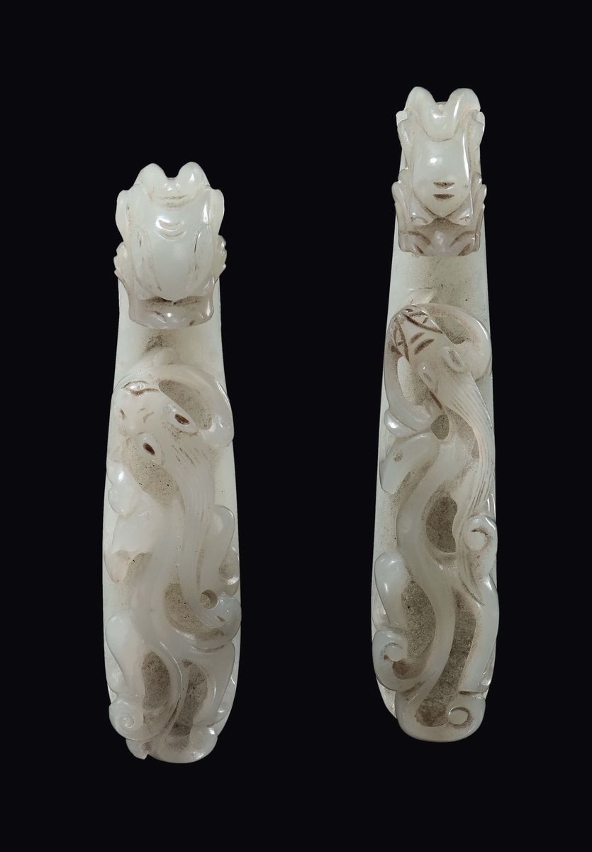 Cina, Dinastia Qing, coppia di fibbie in giada bianca con russet scolpite a guisa di draghetto, e...