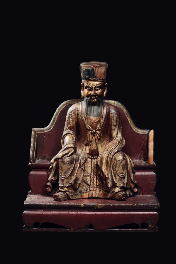 A lacquered wood dignitary with hat sitting on a throne, China, Ming Dynasty, 17th century