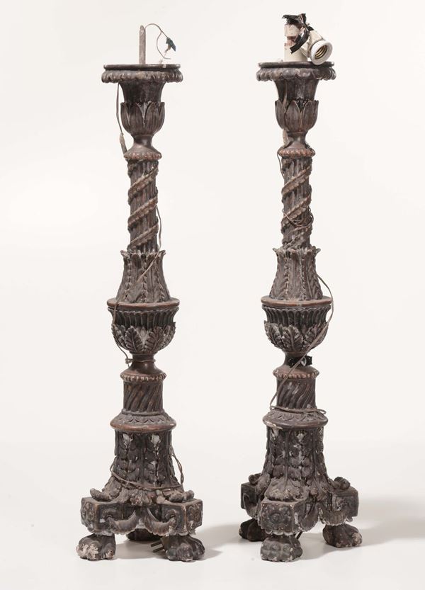 Coppia di torcere in legno intagliato e argentato con lumeggiature dorate