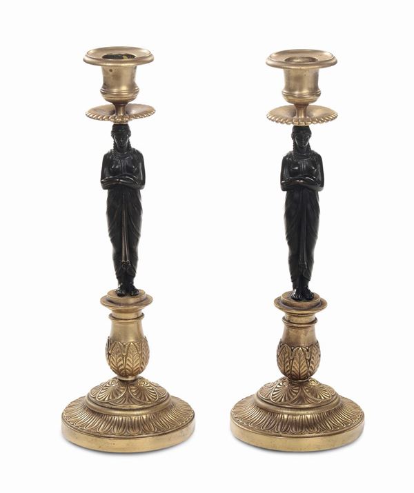 Lotto composto da coppia di candelieri in bronzo dorato con erme in bronzo patinato, XIX Secolo