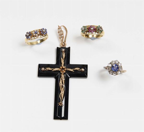 Lotto composto da un crocifisso e tre anelli con rosette di diamanti, zaffiri, smeraldi e rubini