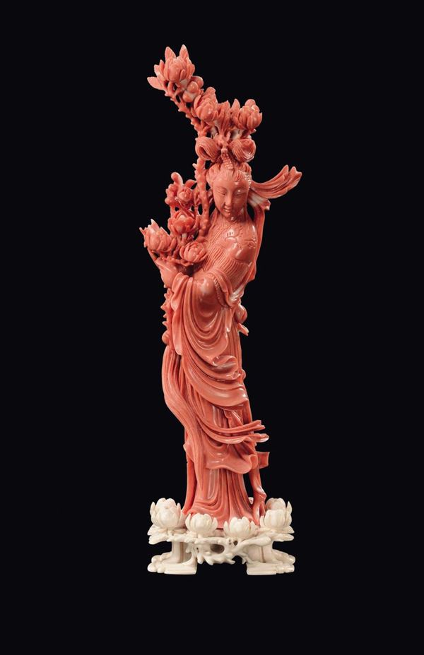 A coral Guanyin figure with branch of flowers and ivory base, China, early 20th century