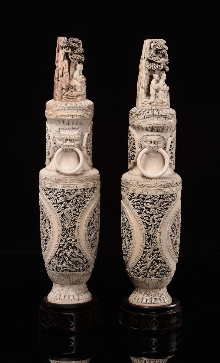 Cina, Canton, Dinastia Qing, Coppia di vasi scolpiti in avorio con manici a forma di teste di dra...