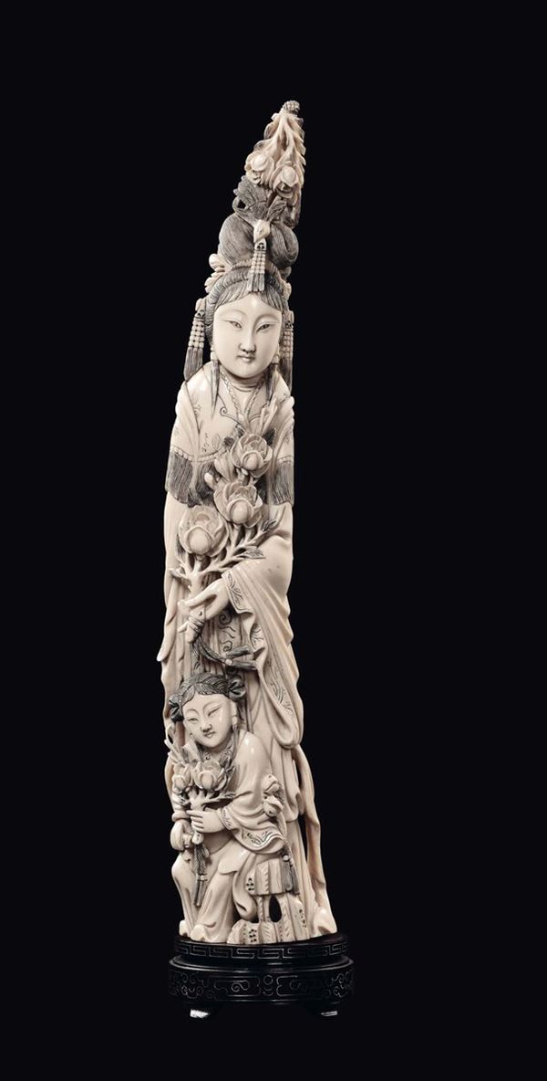 A carved ivory Guanyin and child with flowers group, China, Qing Dynasty, late 19th century
