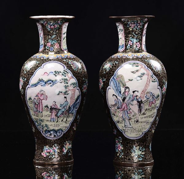 A pair of cloisonné black ground vases with common life scenes within reserves, China, Qing Dynasty, 19th century