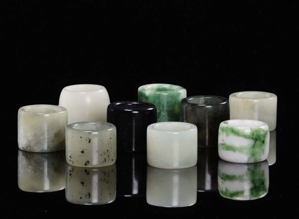 Lot of nine bowmen ring in different shades of jade, China, 20th century