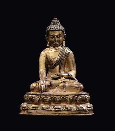 Tibet, XVII secolo, Piccolo Buddha in bronzo dorato seduto su doppio fiore di loto