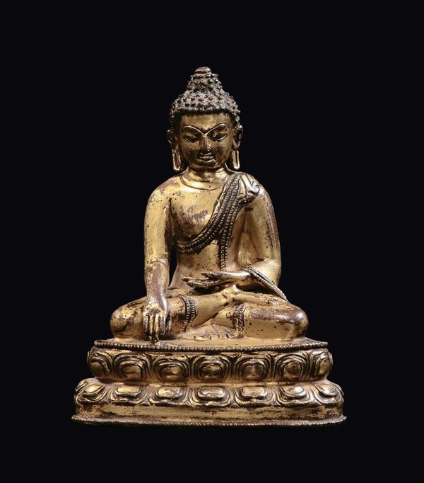 A small gilt bronze Buddha figure on a double lotus flower, Tibet, 17th century
