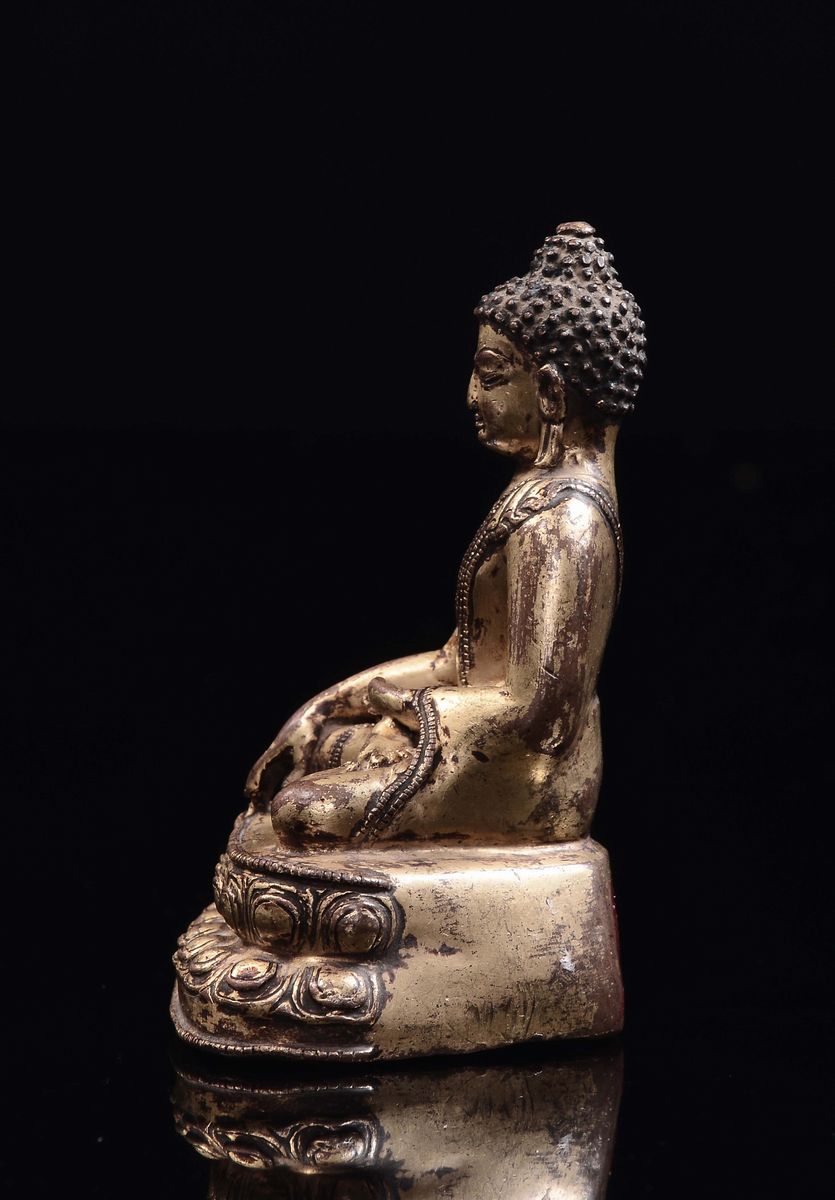Tibet, XVII secolo, Piccolo Buddha in bronzo dorato seduto su doppio fiore di loto