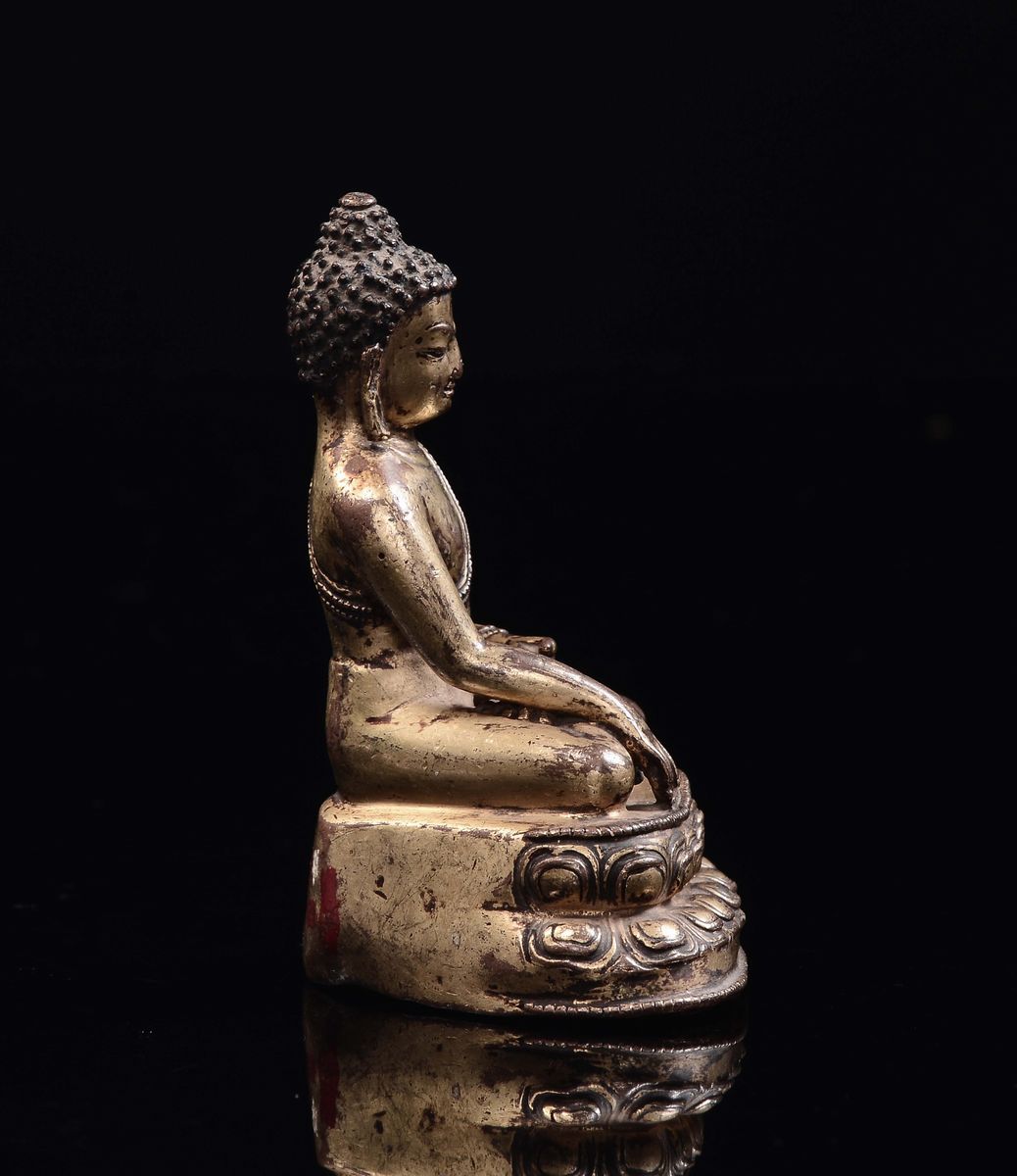 Tibet, XVII secolo, Piccolo Buddha in bronzo dorato seduto su doppio fiore di loto