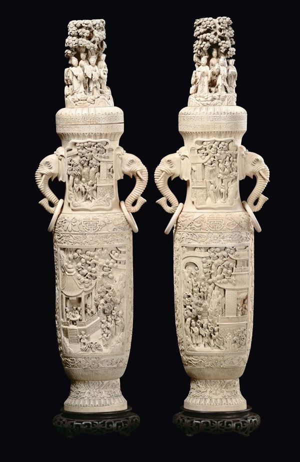 A pair of large ivory vases and cover, elephant heads' double handles, carved with court life scenes,  [..]