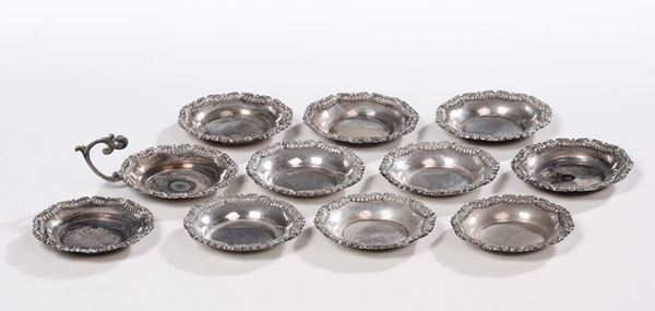 Dodici piattini in argento sbalzato con bordo floreale