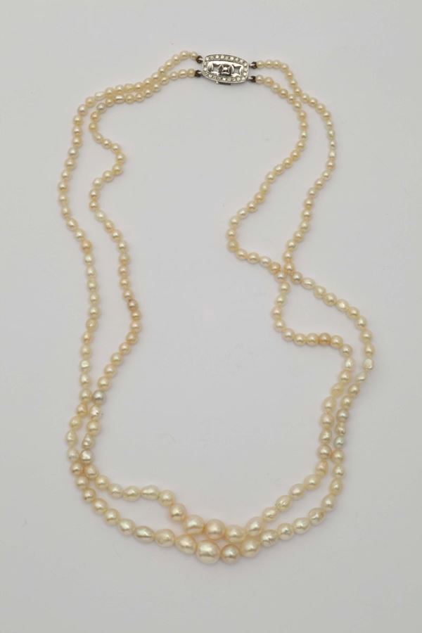 A natural pearl and diamond necklace. Designed as two graduated rows of natural pearls measuring from approximately 2,50 to 6,50 mm