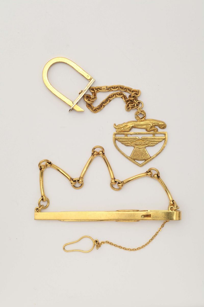 A gold keyring and tie clip. Signed Jaguar and Gucci  - Auction Fine Jewels - I - Cambi Casa d'Aste