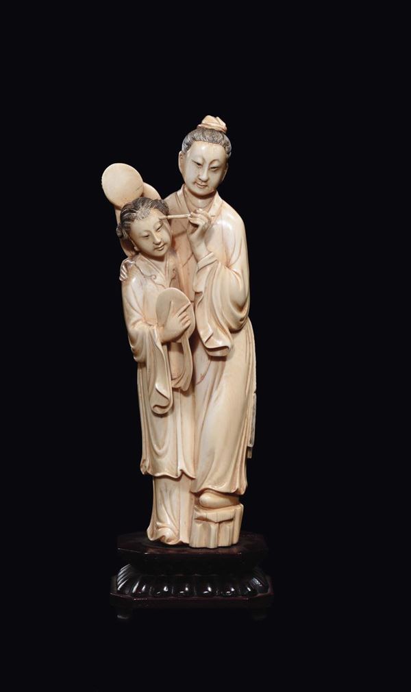 A carved ivory Guanyin and child toilette group, China, Qing Dynasty, late 19th century