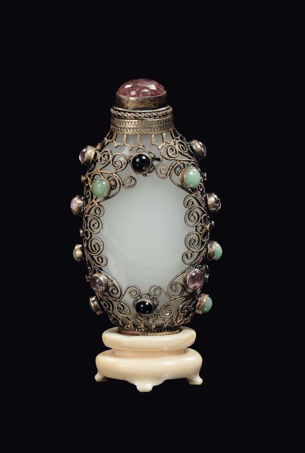 A white jade snuff bottle with silver and semiprecious stones setting on ivory base, China, Qing Dynasty, 19th century