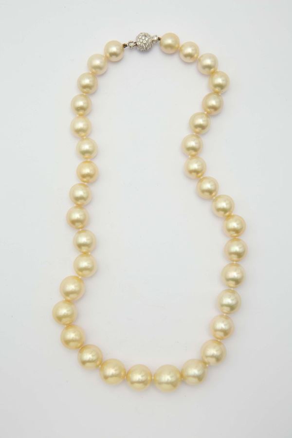 A golden South Sea cultured pearl necklace. A diamond and gold clasp