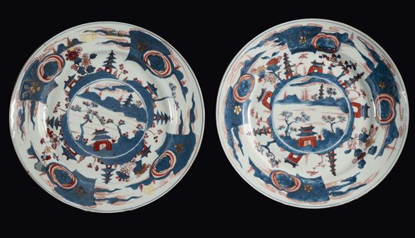 Coppia di piatti in porcellana policroma raffiguranti paesaggio con case, Cina, Dinastia Qing, epoca Kangxi (1662-1722)