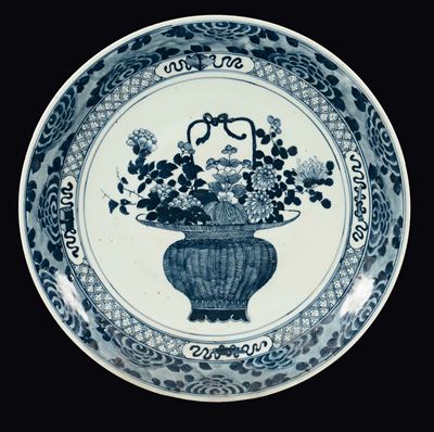 Cina, Dinastia Qing, Grande piatto in porcellana bianca e blu con cestino di fiori, epoca Qianlon...