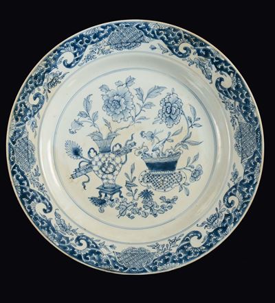 Cina, Dinastia Qing, Grande piatto in porcellana bianca e blu con decorazione di vasi di fiori, e...