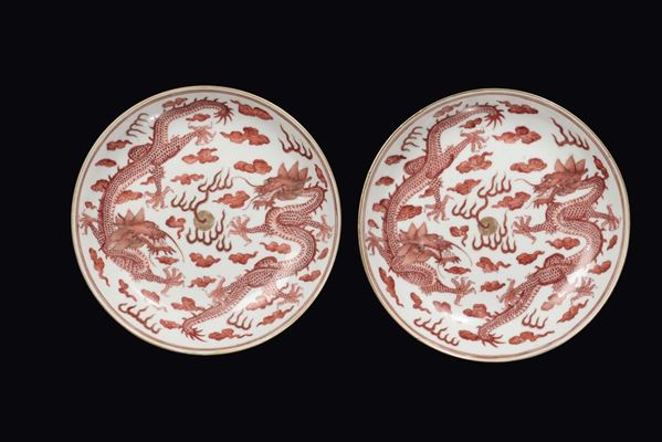 Coppia di piatti in porcellana policroma con due draghi arancioni con lumeggiature in oro, Cina, marca e del periodo Guangxu (1875-1908)