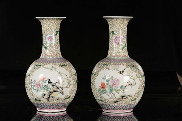 Coppia di vasi in porcellana policroma a fondo giallo con raffigurazioni di uccelli su rami fioriti entro riserve, Cina, XX secolo