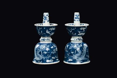 Cina, Coppia di candelieri in porcellana bianca e blu con raffigurazioni di draghi tra le nuvole,...