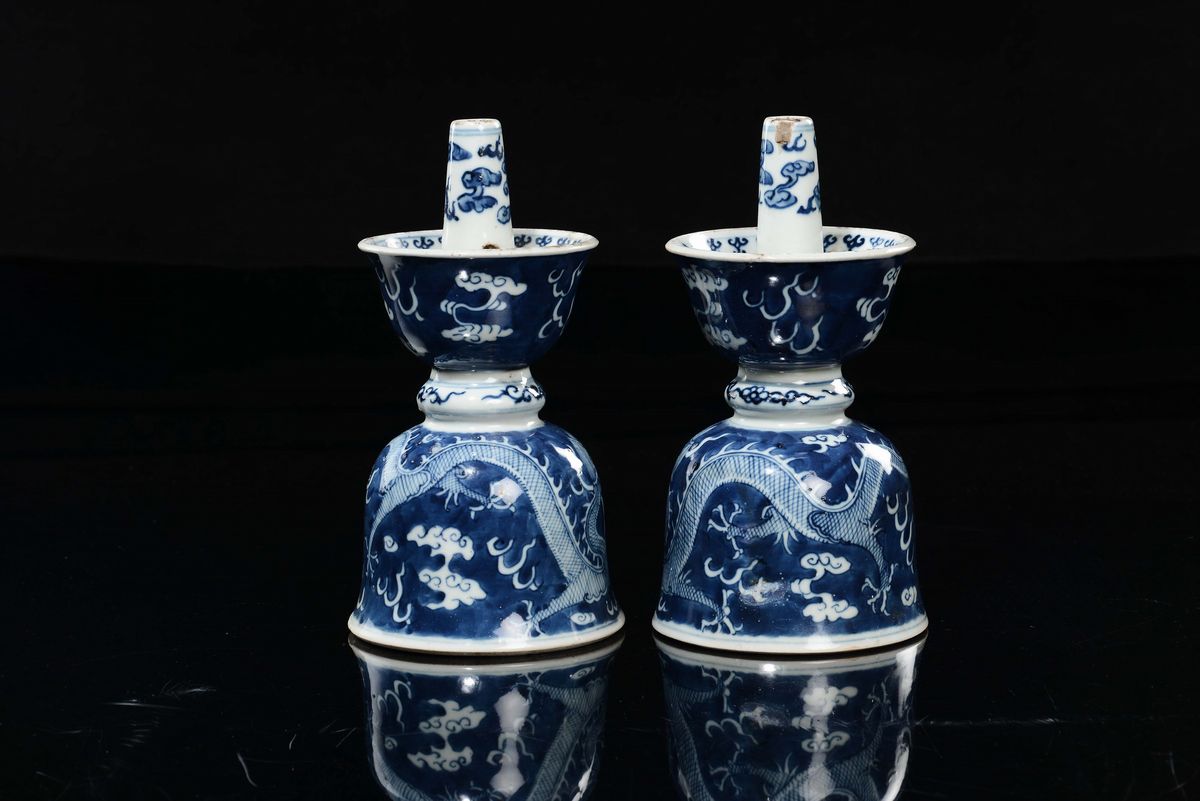 Cina, Coppia di candelieri in porcellana bianca e blu con raffigurazioni di draghi tra le nuvole,...