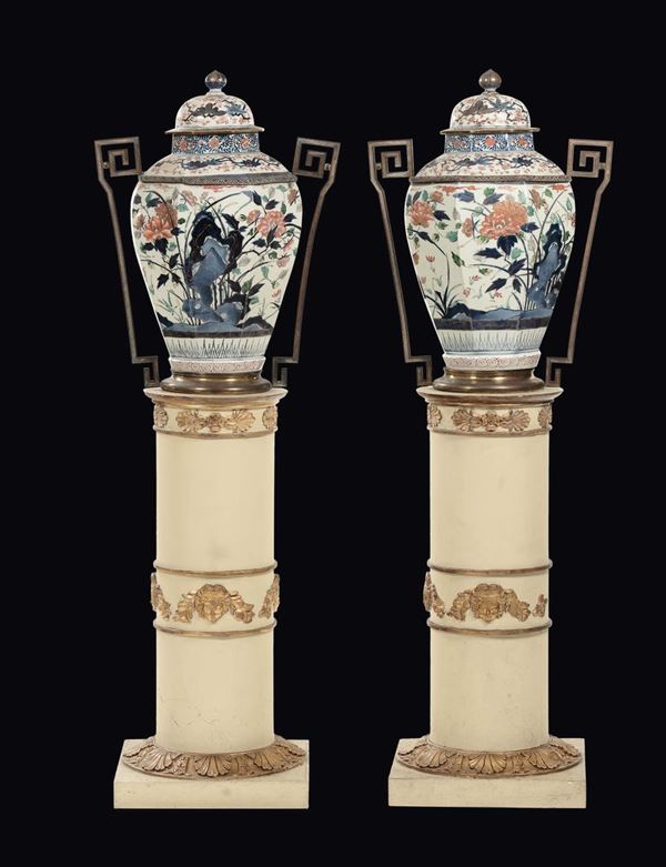 Coppia di potiches in porcellana Arita a decoro floreale con montatura in bronzo dorato e alzate a colonne in legno laccato e dorato, Giappone, fine XVII secolo