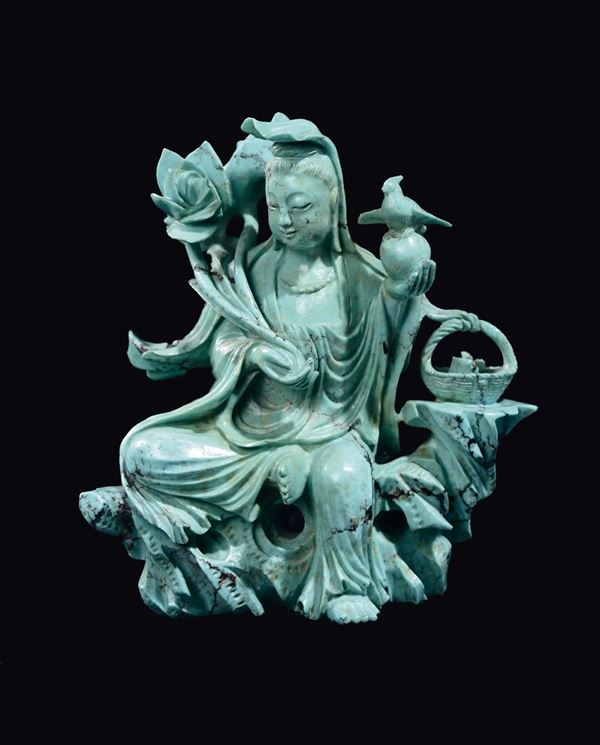 A turquoise figure of Guanyin seated on a rock with a wicker basket, China, 20th century