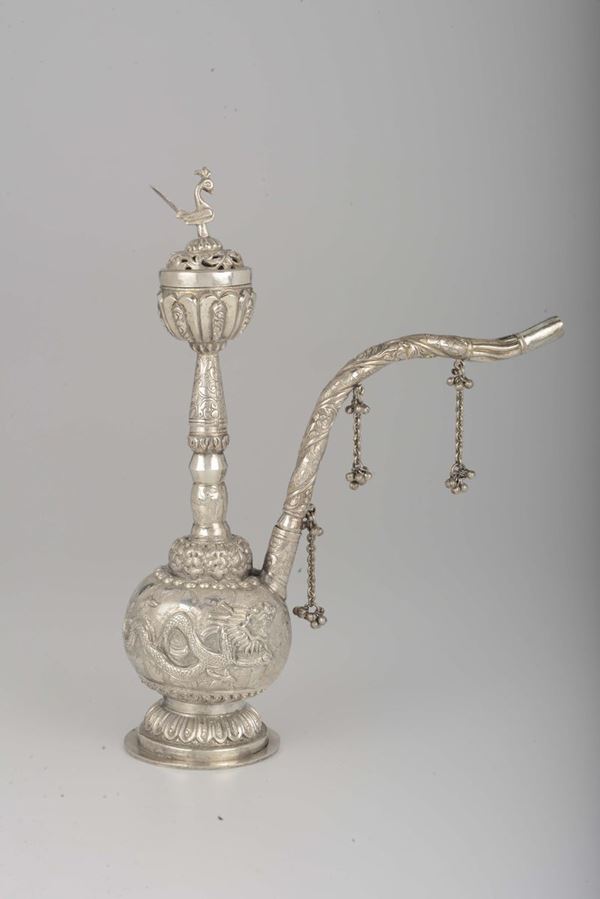 A silver pipe with dragons in relief and small bells on the spout, Tibet, 19th century