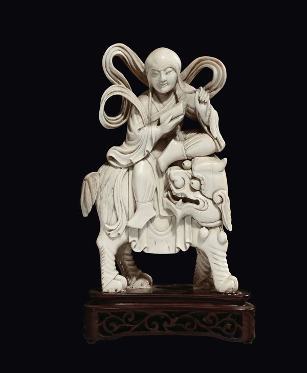 A carved ivory wise man on Pho dog group, China, Qing Dynasty, 19th century