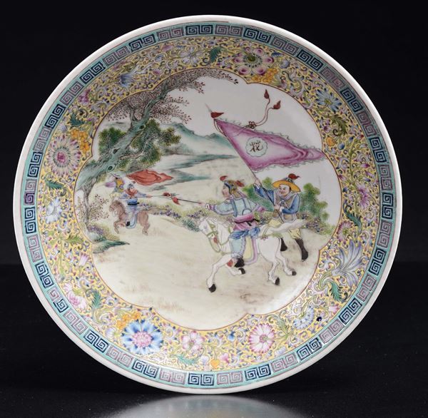 Piatto in porcellana a smalti policromi con riserva raffigurante scena di battaglia, Cina, XX secolo