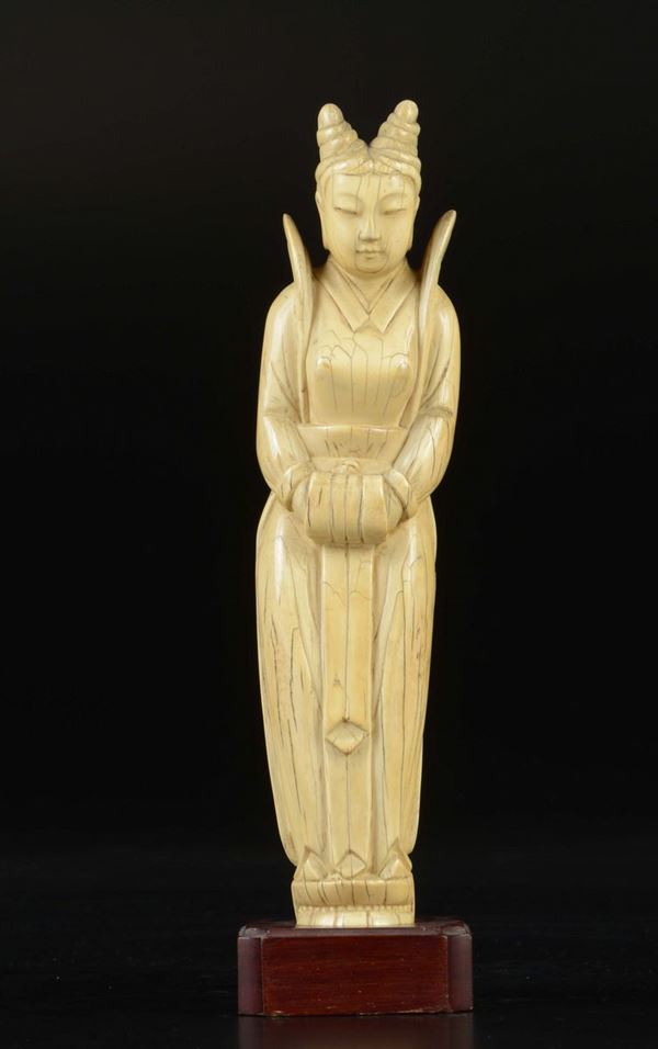 A carved ivory figure of standing Guanyin with hand warmer on a lotus flower, China, Qing Dynasty, 19th century