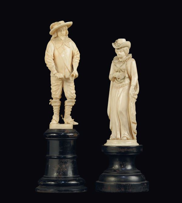 Gruppo di due figure in avorio scolpito raffiguranti personaggi storici su basi tornite in legno ebanizzato, Francia probabilmente Dieppe XIX secolo