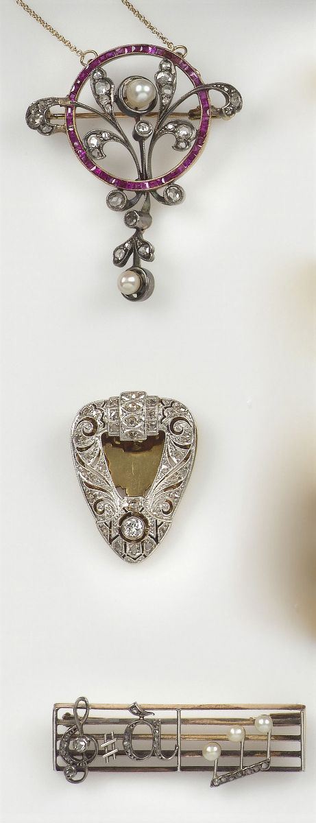 Lotto composto da una clips, una spilla “spartito” Sol à la Doré ed un pendente con rosette di diamanti, rubini e piccole perle  - Asta Antiquariato e Dipinti Antichi - I - Cambi Casa d'Aste