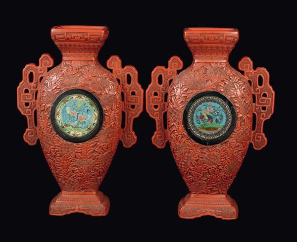 A pair of red lacquer double handles vases with carved naturalistic decoration and flowers and birds within reserves, China, Qing Dynasty, 19th century