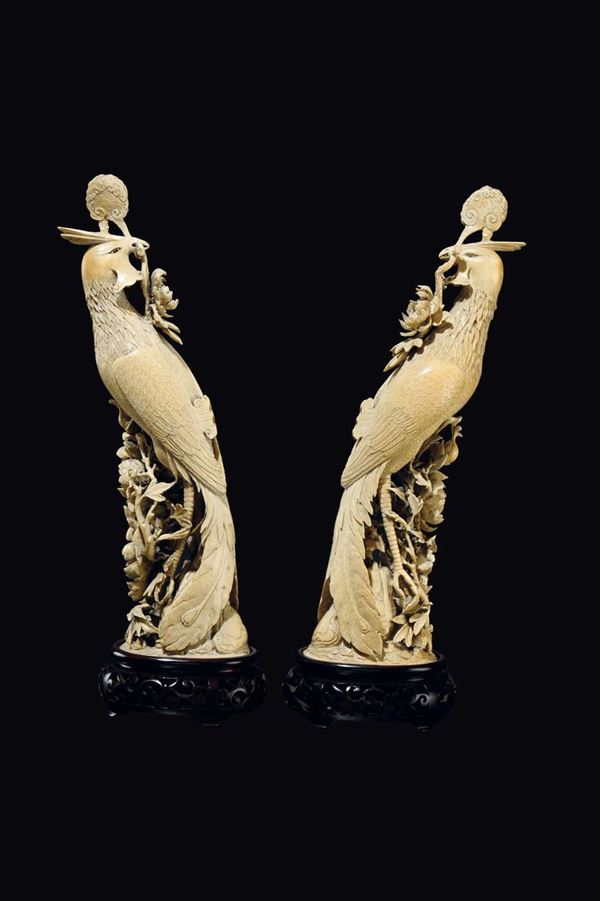 A pair of carved ivory phoenixes with roses in relief, China, Qing Dynasty, late 19th century
