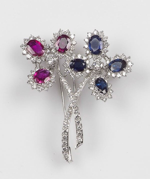 A ruby, sapphire and diamond brooch. The two flowers brooch is mounted in white gold 750/1000