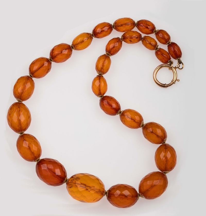 An amber necklace composed of graduated oval beads. Yellow gold clasp  - Auction Fine Jewels - II - Cambi Casa d'Aste
