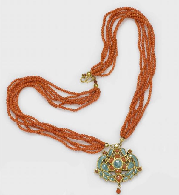 A multi-strand coral bead necklace with a coral and turquoise pendant